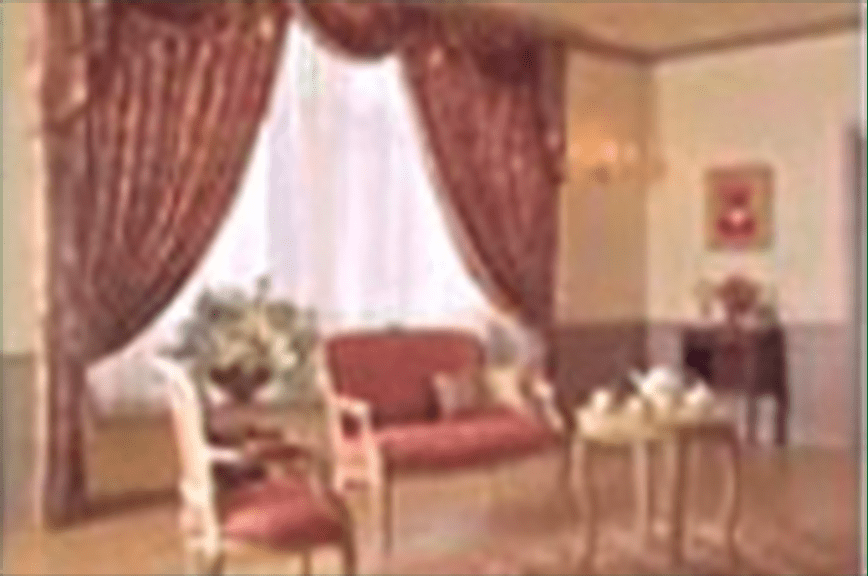 Image of the inside of a house with large curtains visible.